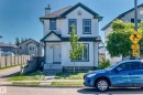 Two-story residence featuring white siding with dark trim, a dark roof, and a chimney - 203 84 Street, Edmonton, AB 