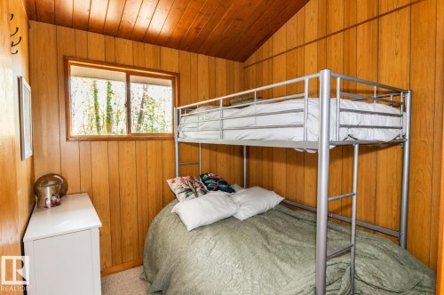 Wood-paneled room featuring a sloped wood-paneled ceiling, a single window, and carpet flooring - 27 Point Drive, Rural St. Paul County, AB - Indoor