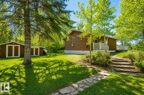 Wood-sided exterior with a white-railed porch - 27 Point Drive, Rural St. Paul County, AB - Outdoor