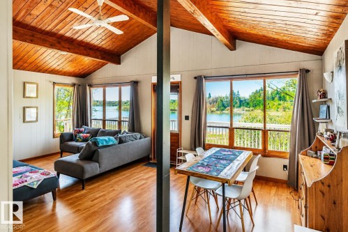 Vaulted wood-paneled ceilings with exposed beams and a ceiling fan, complemented by wood-finish flooring - 27 Point Drive, Rural St. Paul County, AB - Indoor