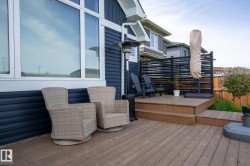Multi-level wood deck featuring a slatted privacy screen and dark blue horizontal siding - 