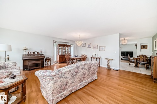 Bright living space featuring wood-finish flooring and light wall colors - 168 Kulawy Drive N, Edmonton, AB 