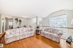 Spacious interior with wood-finish flooring, light-toned walls, and a large grid-pattern window - 