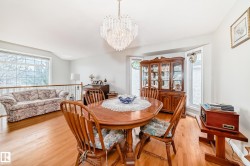 Dining area featuring a contemporary crystal chandelier and wood-finish flooring - 