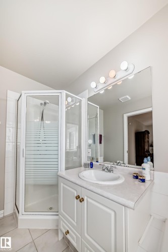 Bathroom featuring a corner shower with a clear glass enclosure and a white tiled base - 168 Kulawy Drive N, Edmonton, AB 
