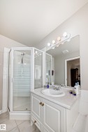Bathroom featuring a corner shower with a clear glass enclosure and a white tiled base - 