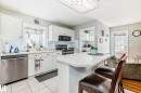 Kitchen featuring white cabinetry, a built-in stainless steel dishwasher, and a white countertop island - 168 Kulawy Drive N, Edmonton, AB 
