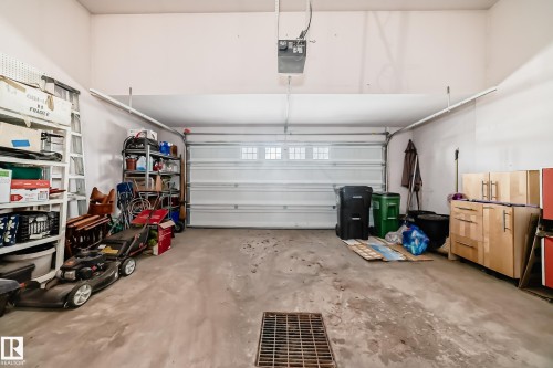 Attached garage featuring a sectional overhead door with window inserts and an automatic opener - 168 Kulawy Drive N, Edmonton, AB 