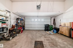Attached garage featuring a sectional overhead door with window inserts and an automatic opener - 
