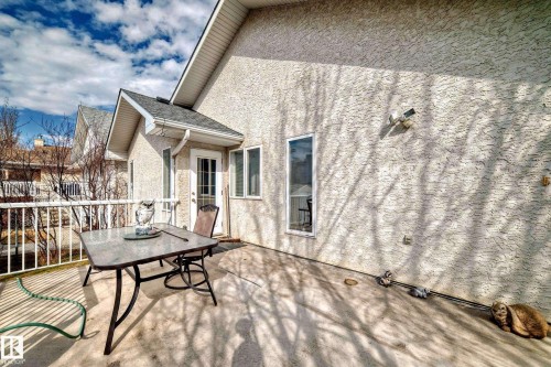 Exterior stucco siding with a gabled roofline and white framed windows - 168 Kulawy Drive N, Edmonton, AB 