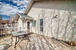 Exterior stucco siding with a gabled roofline and white framed windows - 