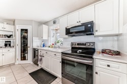Kitchen featuring white cabinetry, stainless steel range, built-in microwave, light countertops, and a full-light pantry door - 