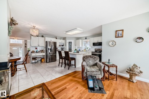 Bright kitchen with white cabinetry, stainless steel appliances, and a central island with seating - 168 Kulawy Drive N, Edmonton, AB 