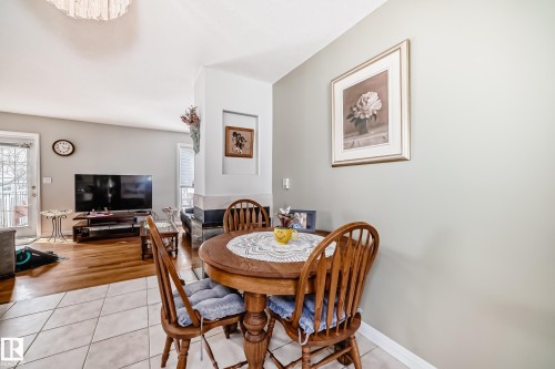 Dining space featuring a round wood dining table, matching wood chairs, and neutral wall paint - 168 Kulawy Drive N, Edmonton, AB 