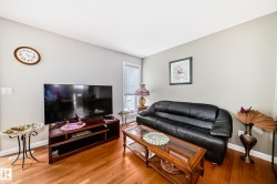 Living area featuring wood-finish flooring, light grey painted walls, and white trim - 