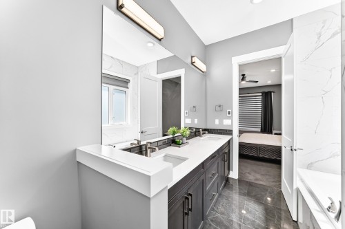Bathroom featuring a dual vanity with dark cabinetry, white countertops, and undermount sinks - 1781 Melrose Crescent, Edmonton, AB 