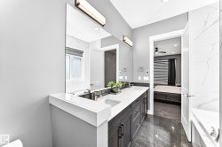 Bathroom featuring a dual vanity with dark cabinetry, white countertops, and undermount sinks - 