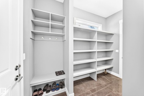 Mudroom featuring built-in shelving, a bench with shoe storage, and coat hooks - 1781 Melrose Crescent, Edmonton, AB 