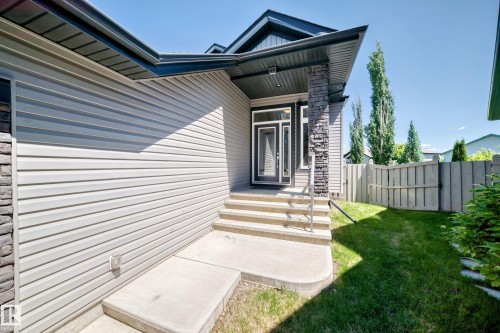 Contemporary exterior with light gray siding and dark stone accents - 1781 Melrose Crescent, Edmonton, AB 