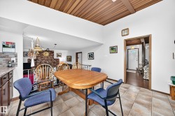 Dining area featuring tile flooring, a wood-finish ceiling, and a wood-finish table - 