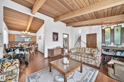 Living area featuring wood-finish flooring and a wood-paneled vaulted ceiling with exposed beams - 