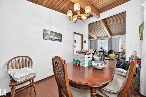 Wood-finish flooring with white walls and a wood-paneled ceiling featuring exposed beams - 13804 87 Street, Edmonton, AB 