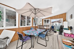 Sunroom featuring wood-finish wall paneling, multiple windows, and a sliding glass door - 