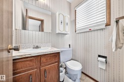 Bathroom with a wood-finish vanity, a white countertop, and an integrated sink - 