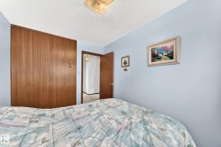 Full-height bi-fold closet doors with wood-finish panels and round hardware - 