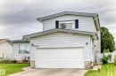 Two-story residence featuring light-colored horizontal siding, an attached garage, and a concrete driveway - 13804 87 Street, Edmonton, AB 
