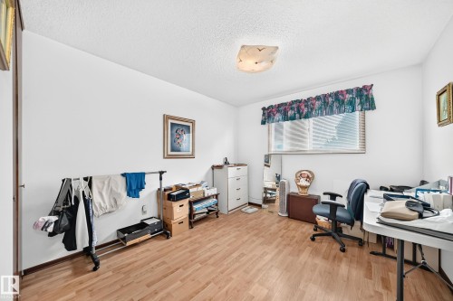 Room featuring wood-finish flooring, white walls, and a textured ceiling - 13804 87 Street, Edmonton, AB 