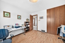 Versatile room featuring wood-finish flooring, white walls, and a textured ceiling - 