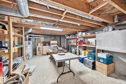 Utility room featuring exposed ceiling joists, concrete foundation walls, and vinyl flooring - 13804 87 Street, Edmonton, AB 