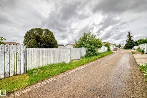 Gated access with a combination of wood fencing and chain-link fencing, bordering a paved driveway - 13804 87 Street, Edmonton, AB 
