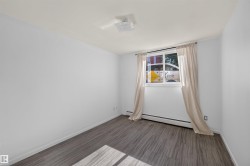 Room featuring wood-finish flooring, a white ceiling, and white painted walls - 