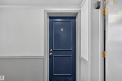 Navy blue paneled entry door with brass hardware and numbered plaque - 