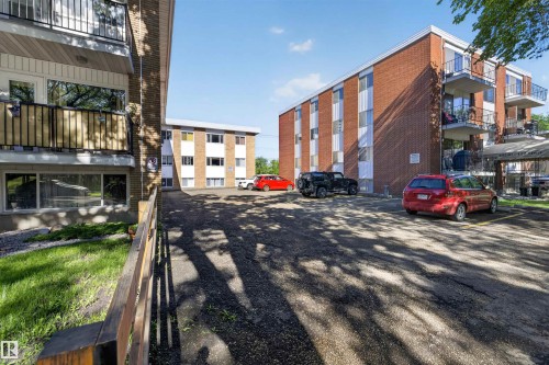 Brick exterior apartment building with multiple private balconies featuring black metal railings - 6 10230 122 Street Nw, Edmonton, AB 