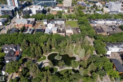 Aerial perspective featuring a prominent urban park with a central pond and island - 