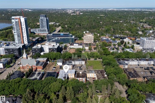 Aerial perspective showcasing a mixed-use neighborhood with mature tree coverage - 6 10230 122 Street Nw, Edmonton, AB 