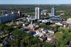 Central urban property with mature trees, surrounded by varied architectural styles including traditional brick and modern high-rises - 
