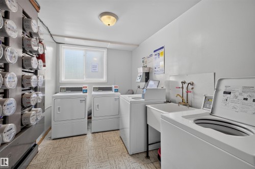 Dedicated laundry room right out unit door featuring multiple washing machines and dryers - 6 10230 122 Street Nw, Edmonton, AB 