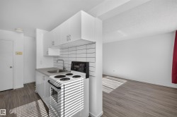 Compact kitchen with white cabinetry, a subway tile backsplash, and a stainless steel sink - 