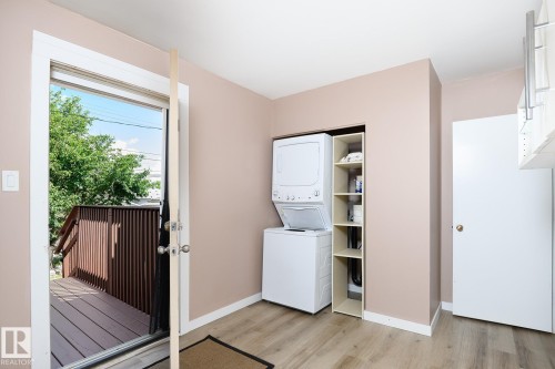 Laundry area with wood-finish flooring and direct access to an exterior deck - 9607 75 Street, Edmonton, AB 