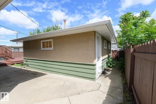 Exterior structure featuring stucco siding, green skirting, and white trim - 9607 75 Street, Edmonton, AB 