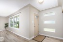 Front entry featuring a light-colored door with decorative glass, three horizontal windows, and a flush mount ceiling light - 9607 75 Street, Edmonton, AB 