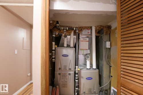 Dedicated utility closet housing two Carrier brand furnaces - 9607 75 Street, Edmonton, AB 