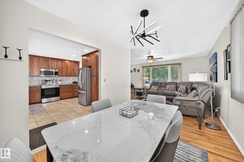 Dining area with a modern chandelier and hard-surface flooring - 11708 138 Avenue Nw, Edmonton, AB 
