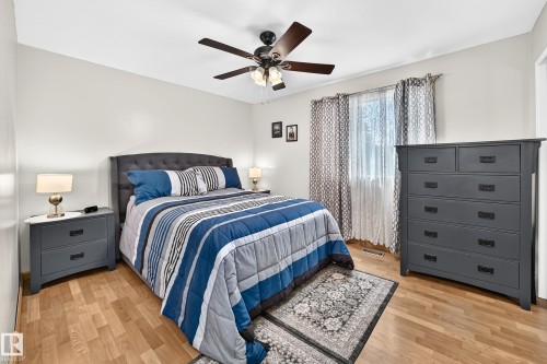 Room featuring wood-finish flooring, light-toned walls, and a ceiling fan with integrated lighting - 11708 138 Avenue Nw, Edmonton, AB 