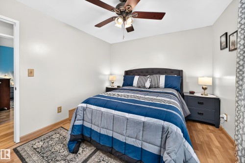 Bright room featuring wood-finish flooring, light-toned walls, and a ceiling fan with integrated lighting - 11708 138 Avenue Nw, Edmonton, AB 