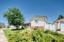Cream-colored siding exterior with a brick skirt and a brown-trimmed roofline - 11708 138 Avenue Nw, Edmonton, AB 